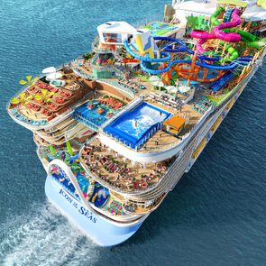 Cruise ship sails, featuring colorful water slides and pools, surrounded by open sea. The text reads 