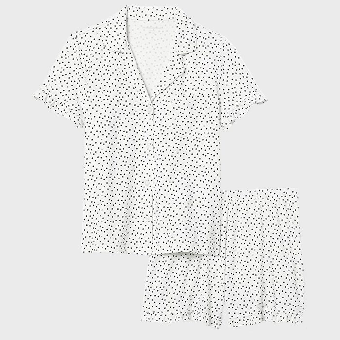 Polka dot short-sleeve shirt and shorts are laid flat on a plain surface.