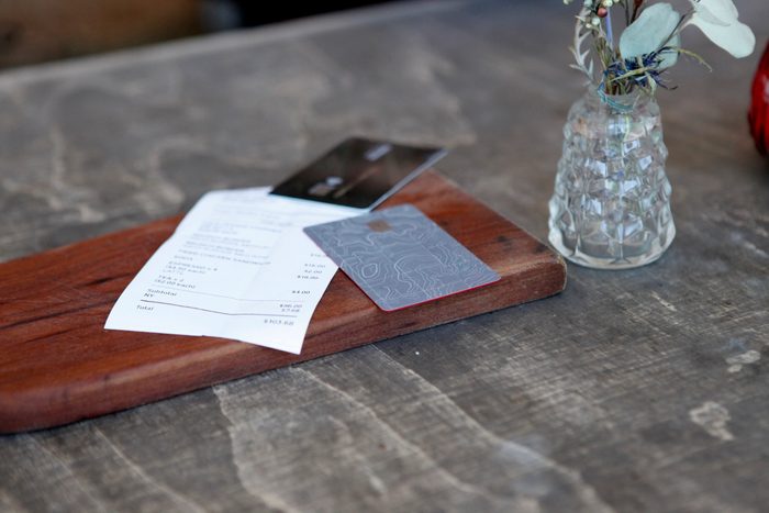 Close-up of credit cards and bill on table in rustic restaurant