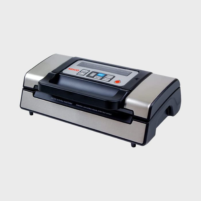 Vacuum sealer resting on a surface; features buttons and digital display; metallic with black accents; text 