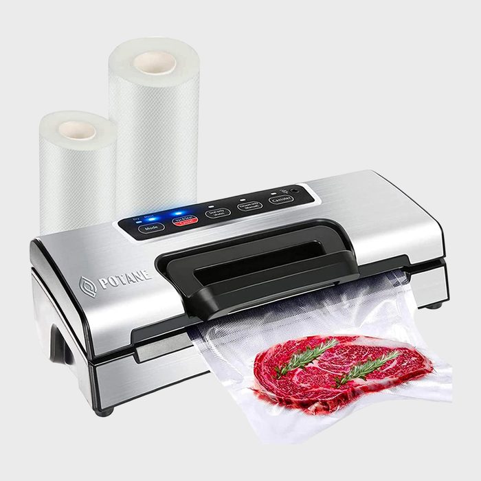 Vacuum sealer sealing a steak in plastic, displayed with two rolls of vacuum-seal bags on a plain background.