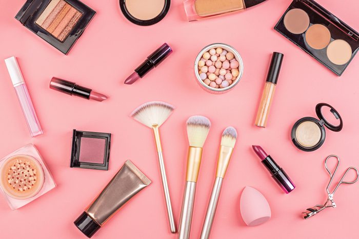 Cosmetic products on pink background. Set of luxury decorative cosmetics with copy space, flat lay, top view, mockup, template