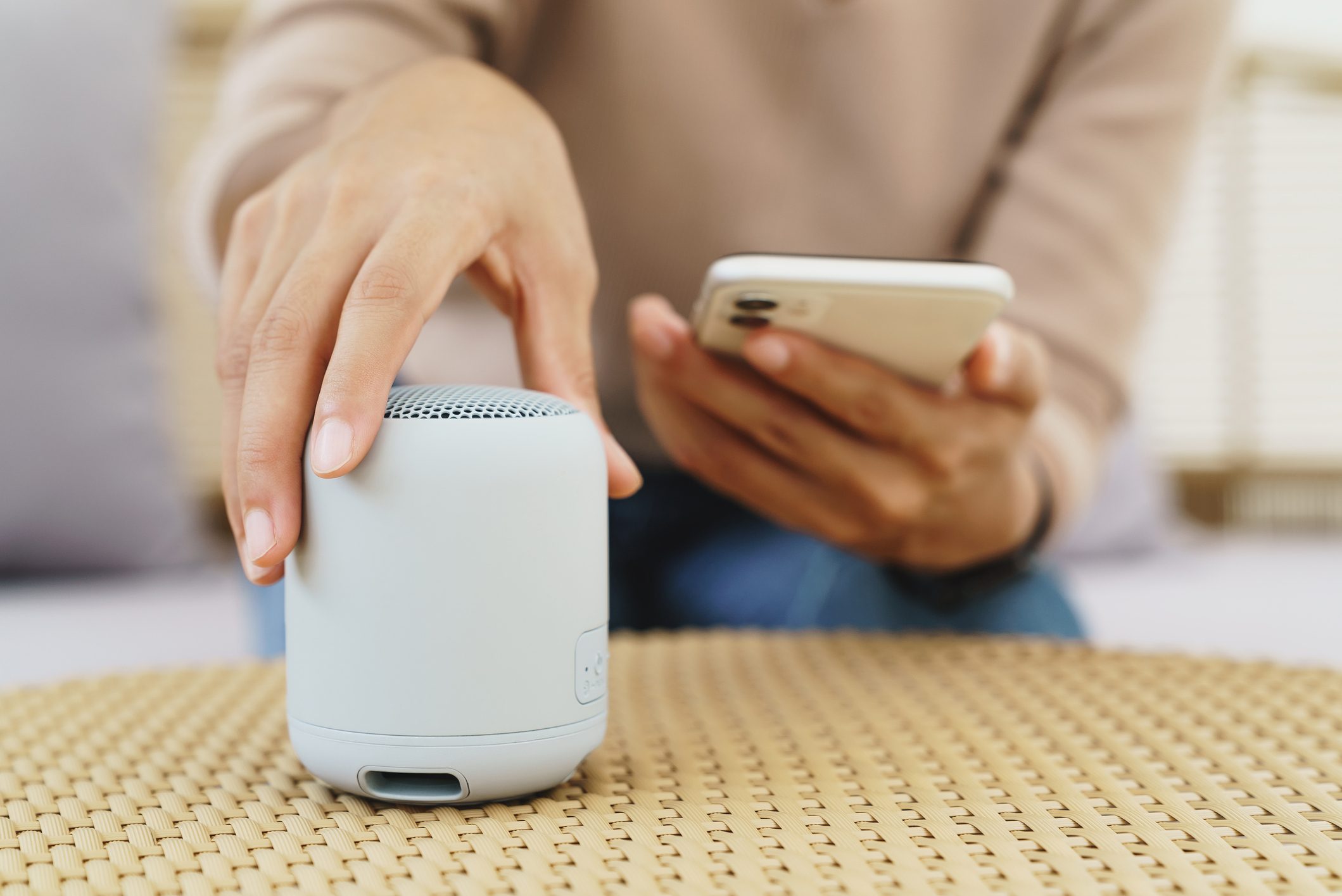 close-up on hand using phone connecting speaker bluetooth
