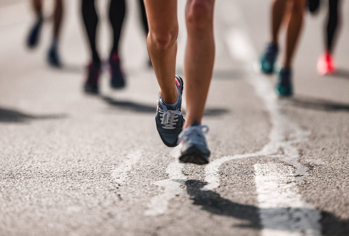 Unrecognizable marathon runner in motion on the road.