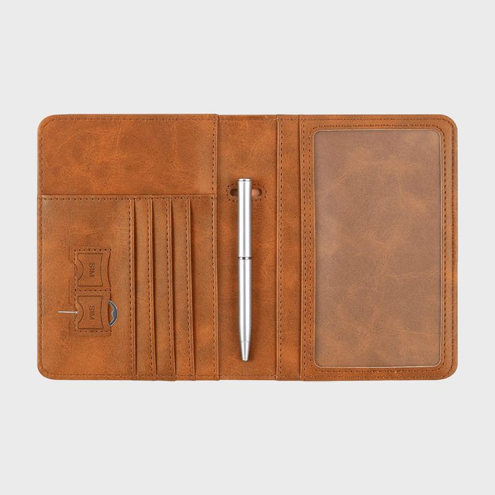 Leather travel wallet with slots holds a pen, cards, SIM card tools; features a transparent pocket, situated on a plain light background.