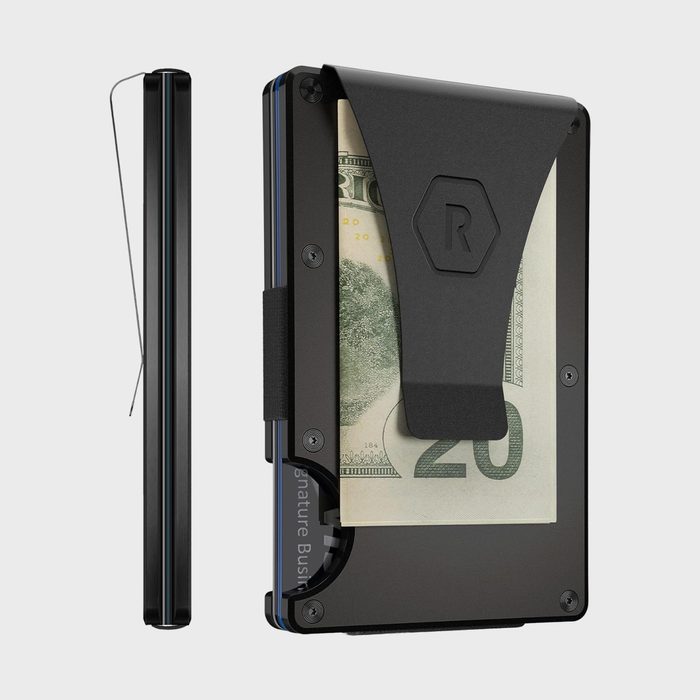 Slim black wallet secures dollar bill with a clip in a minimalist design, shown on a light gray background.