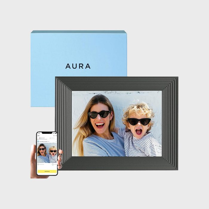Photo frame displaying a smiling woman and child wearing sunglasses; a phone and box with the word 