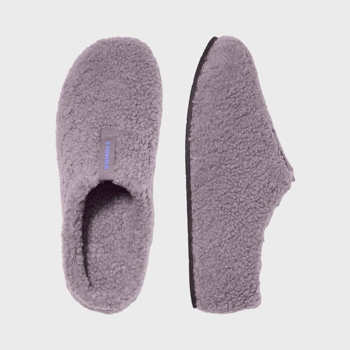 Gray fleece slippers displayed side by side; left shows top view, right shows side profile. Tag reads 