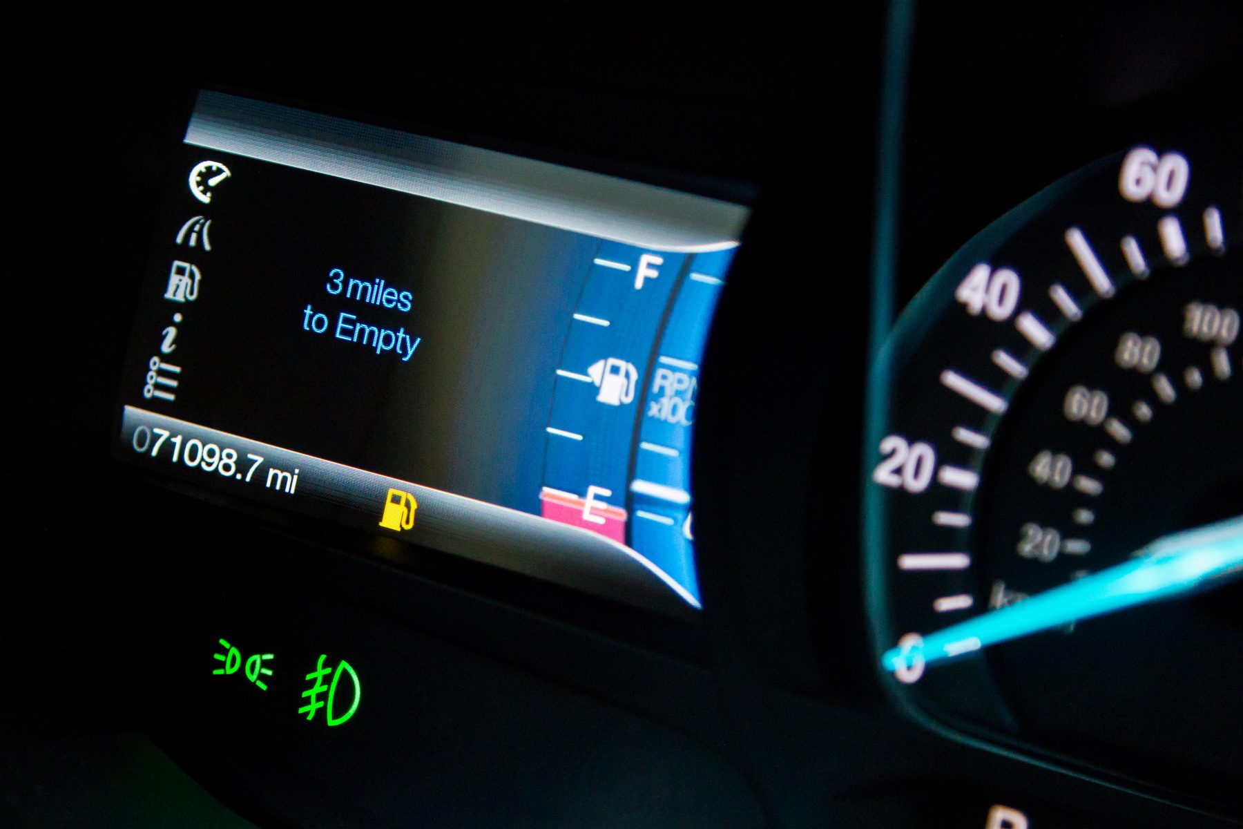 Car dashboard displays "3 miles to Empty," speedometer shows 0, with odometer at 071098.7 miles, indicating low fuel warning.