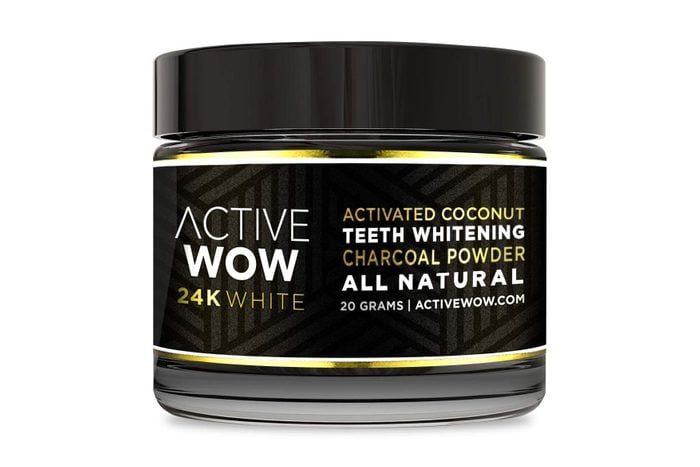 A jar containing activated coconut charcoal powder sits against a plain background. Label reads: 