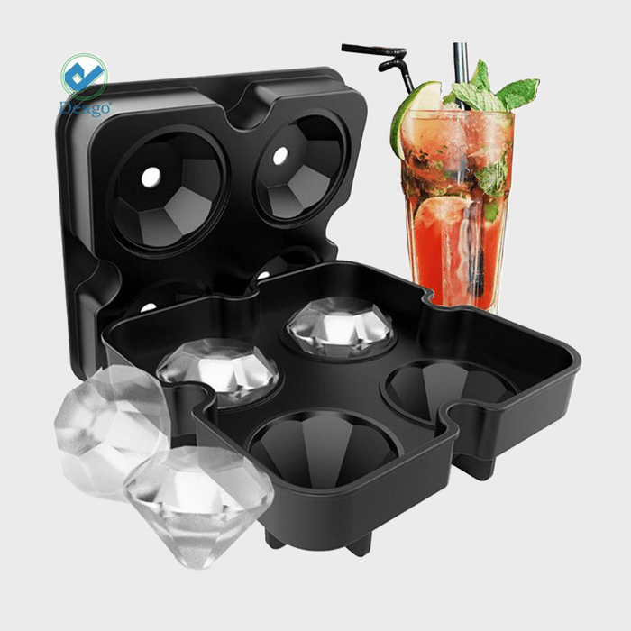Black ice mold creates diamond-shaped ice beside a cocktail glass with mint and lime on a gray background.