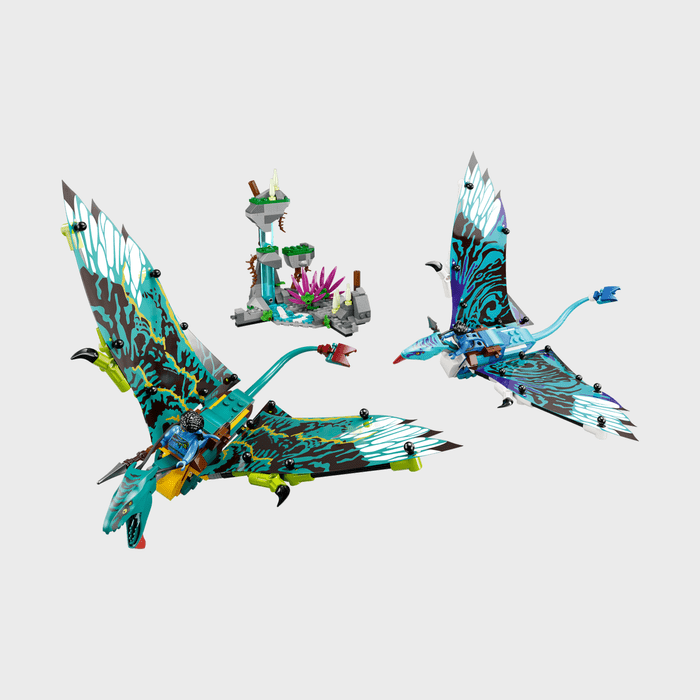 Two colorful, patterned model birds fly, surrounding a small, tree-like structure with purple and green elements on a plain background.