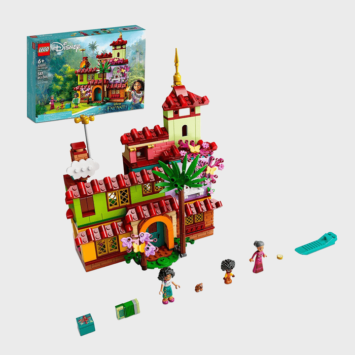 LEGO house with red roof and palm tree, surrounded by three mini-figures and accessories. Encanto-themed box displayed in the background.