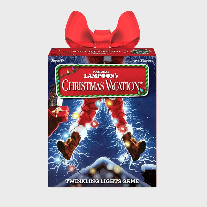 Box with Santa's lower legs electrified, surrounded by dark sky and rooftop lights. Red bow on top. Text: 