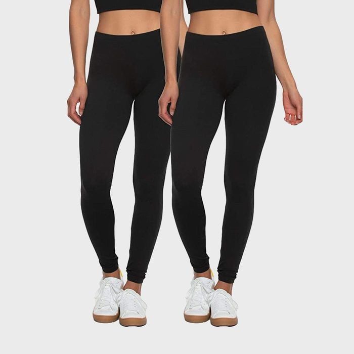 Two people wearing black leggings and white sneakers stand against a plain background.