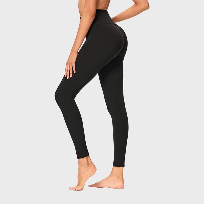 Leggings cover a standing person's legs, highlighting the fit. The background is plain and minimalistic.