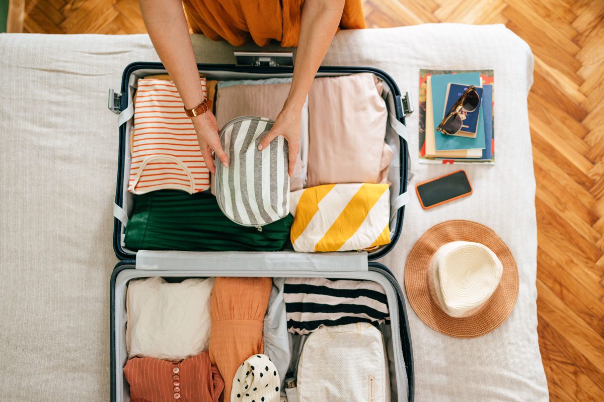 Woman Putting A Bag In Her Suitcase