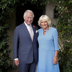 King Charles and Queen Camilla in front of an ivy wall