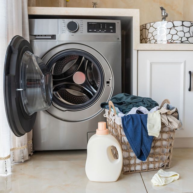 Basket with laundry and washing machine