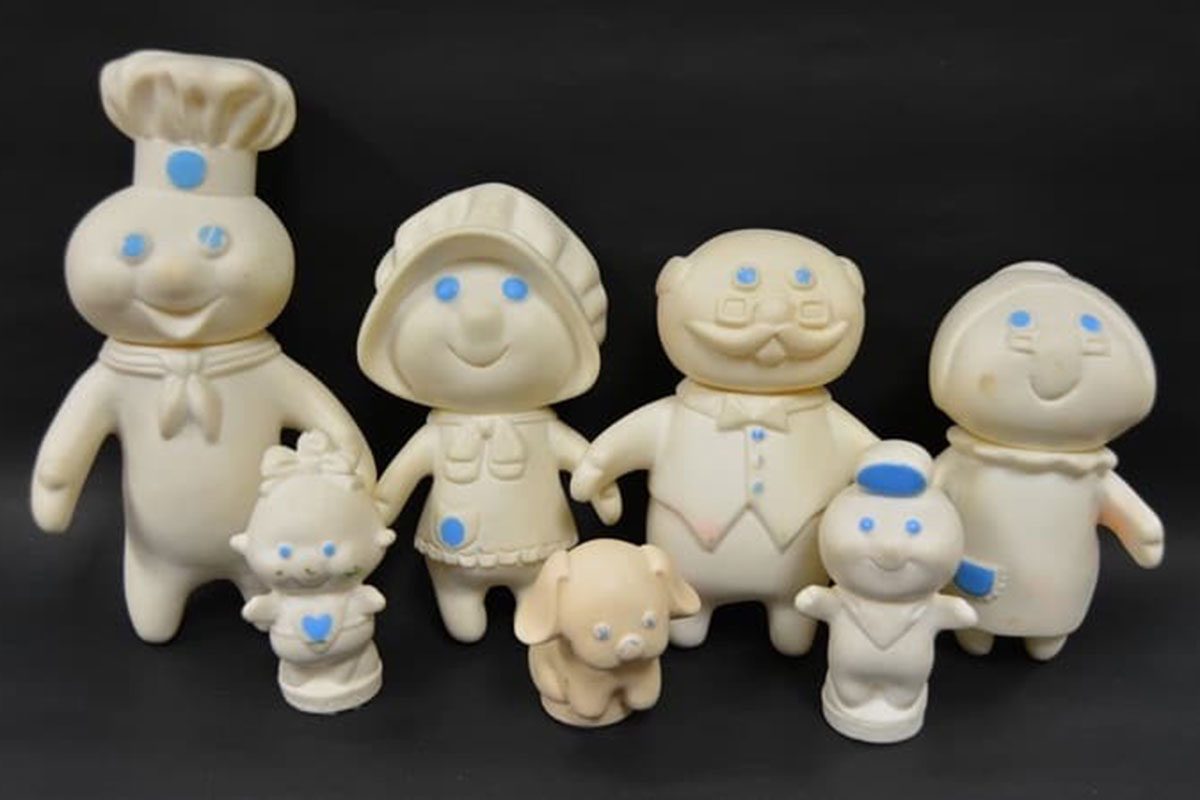 Seven members of the pillsbury doughboy "family" on a black background
